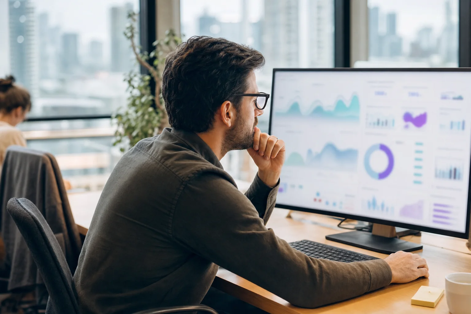 Marketing professional reviewing an analytics dashboard on a large screen in a Melbourne office